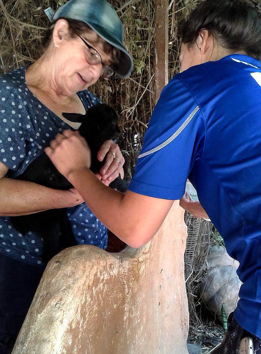 Ruchie and German Volunteer feeding newborn goat